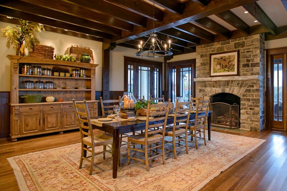 A dining room with a long table and chairs and a fireplace.