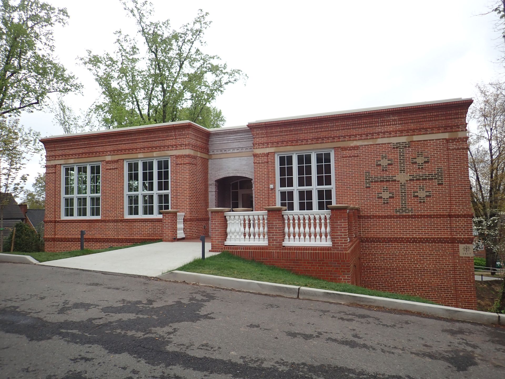 A large red brick building with a white railing
