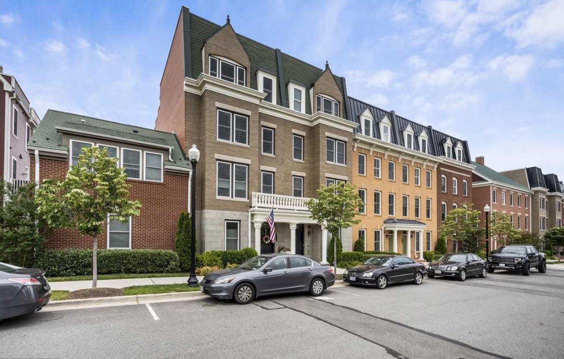 A row of cars are parked in front of a large building