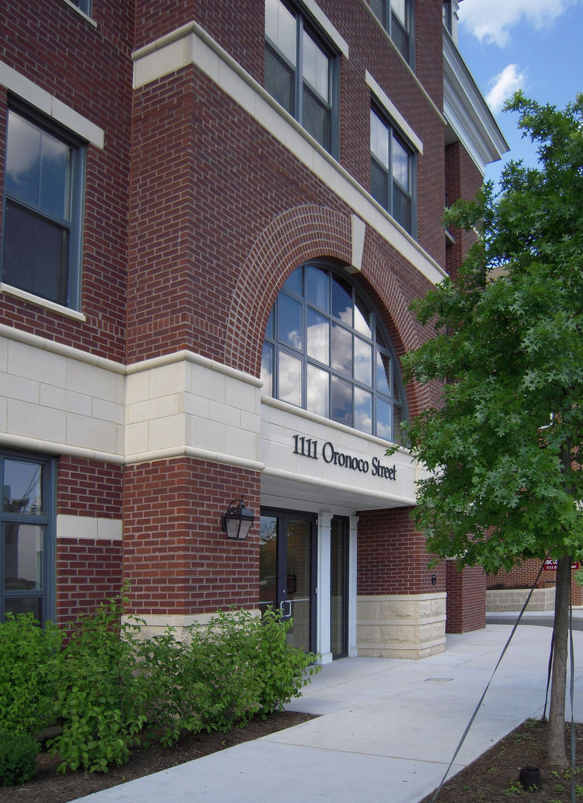 A large brick building with a tree in front of it