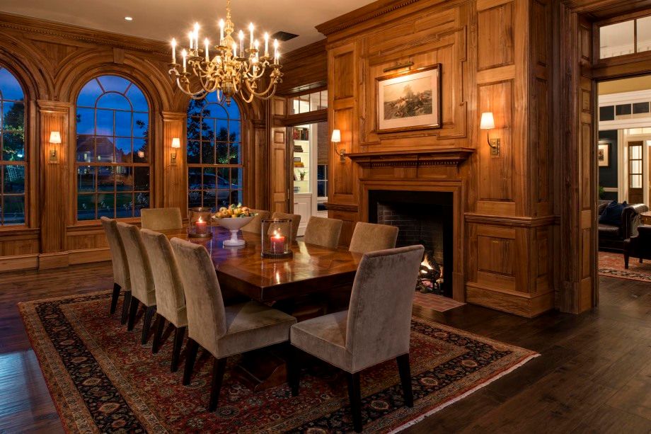 A dining room with a long table and chairs and a fireplace