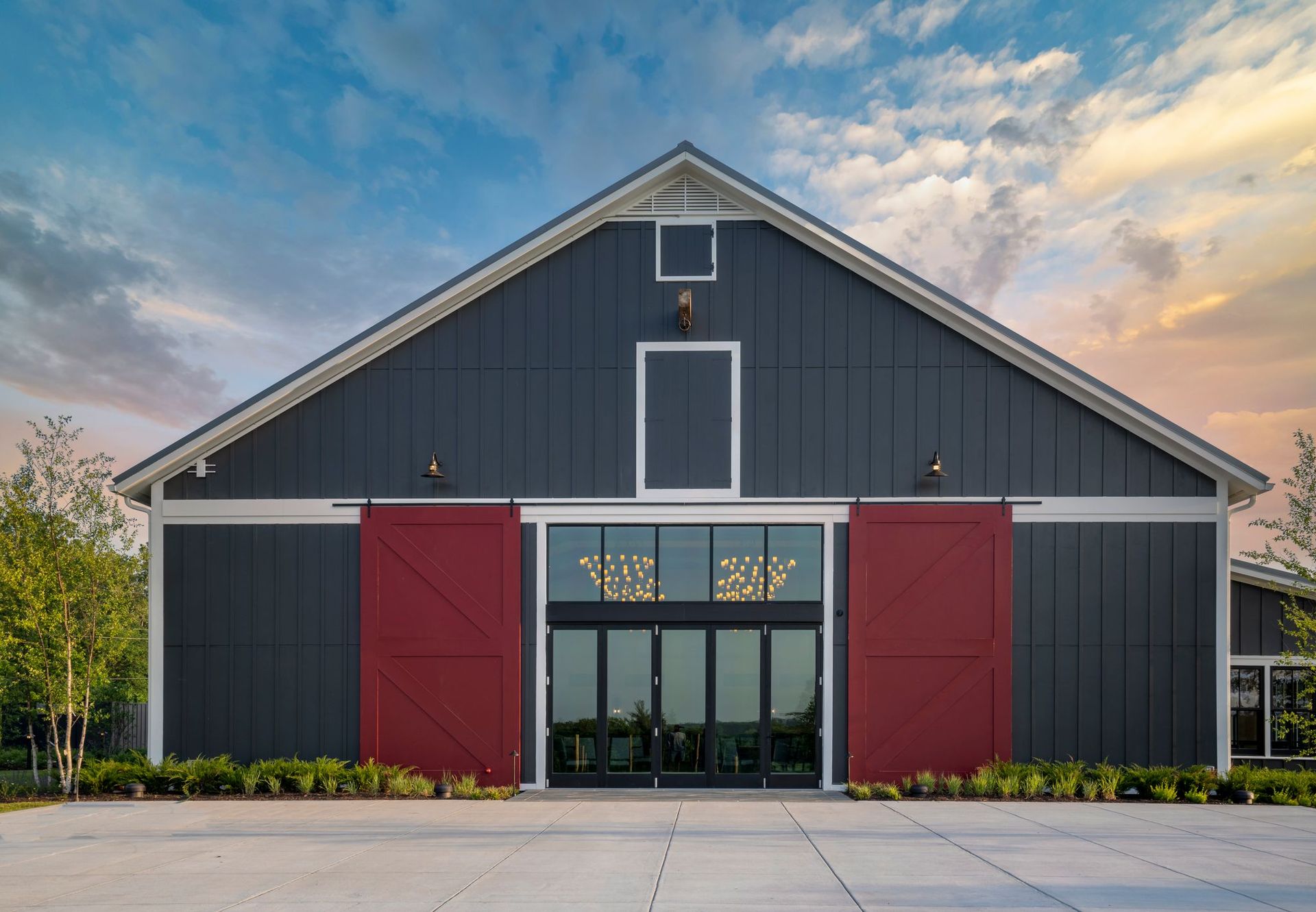 A large black barn with red sliding barn doors