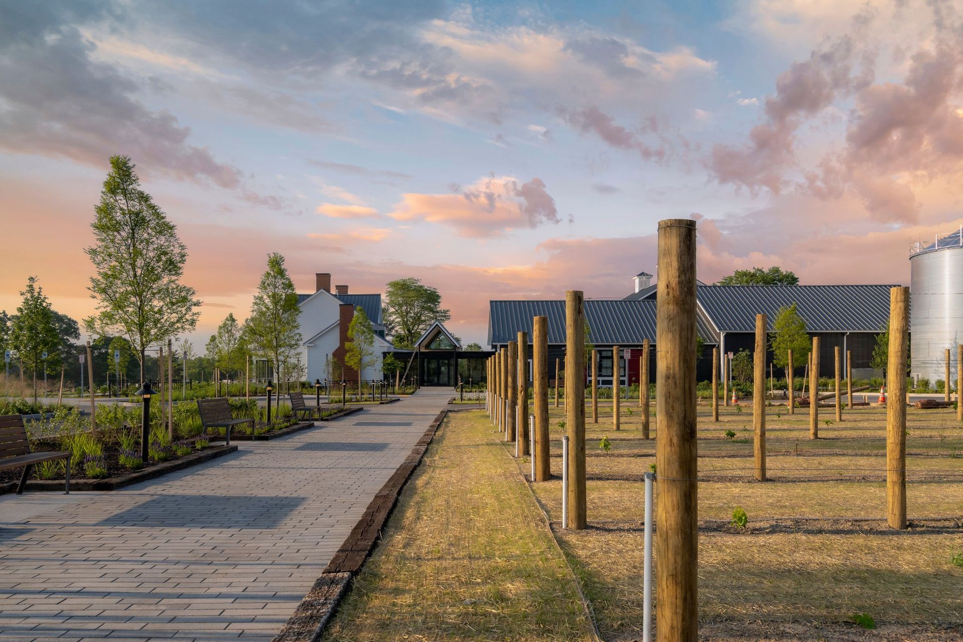 A wooden fence surrounds a field with a building in the background.