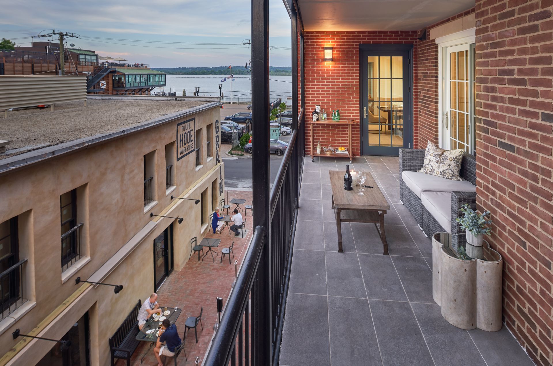 A balcony with a view of a city and a table and chairs on it.