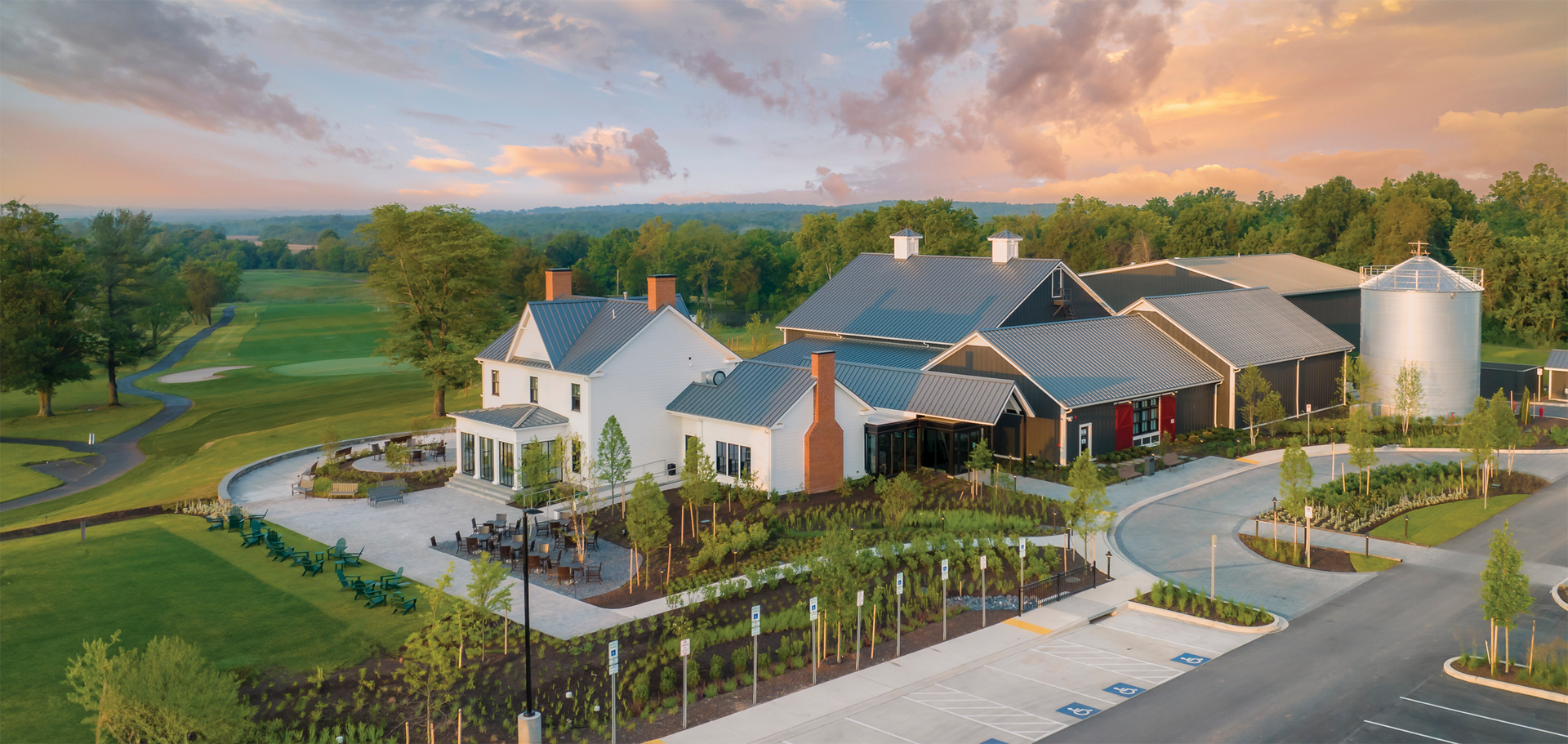 An aerial view of a large house surrounded by trees and a golf course.
