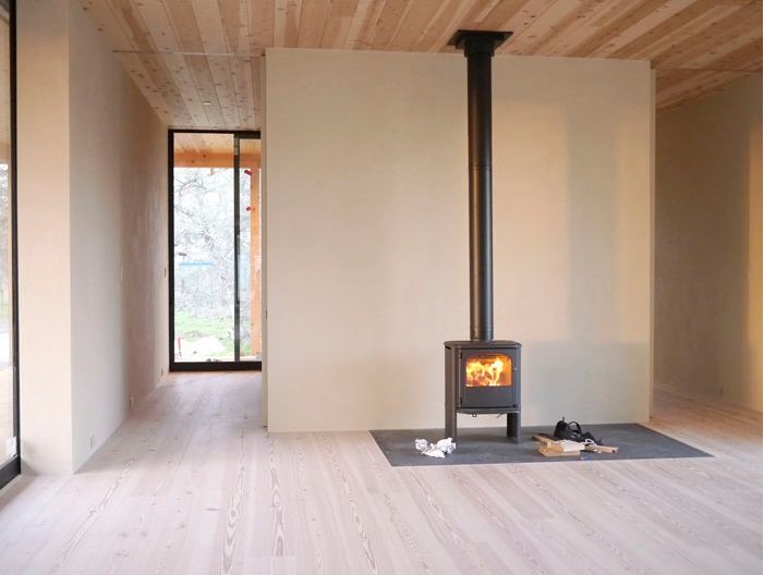 An empty room with a wood stove in the middle of it