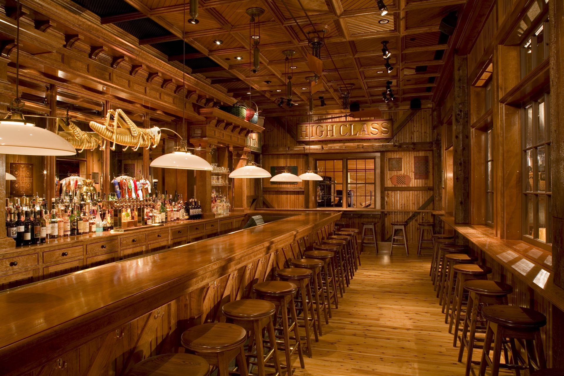 A long wooden bar in a restaurant with stools