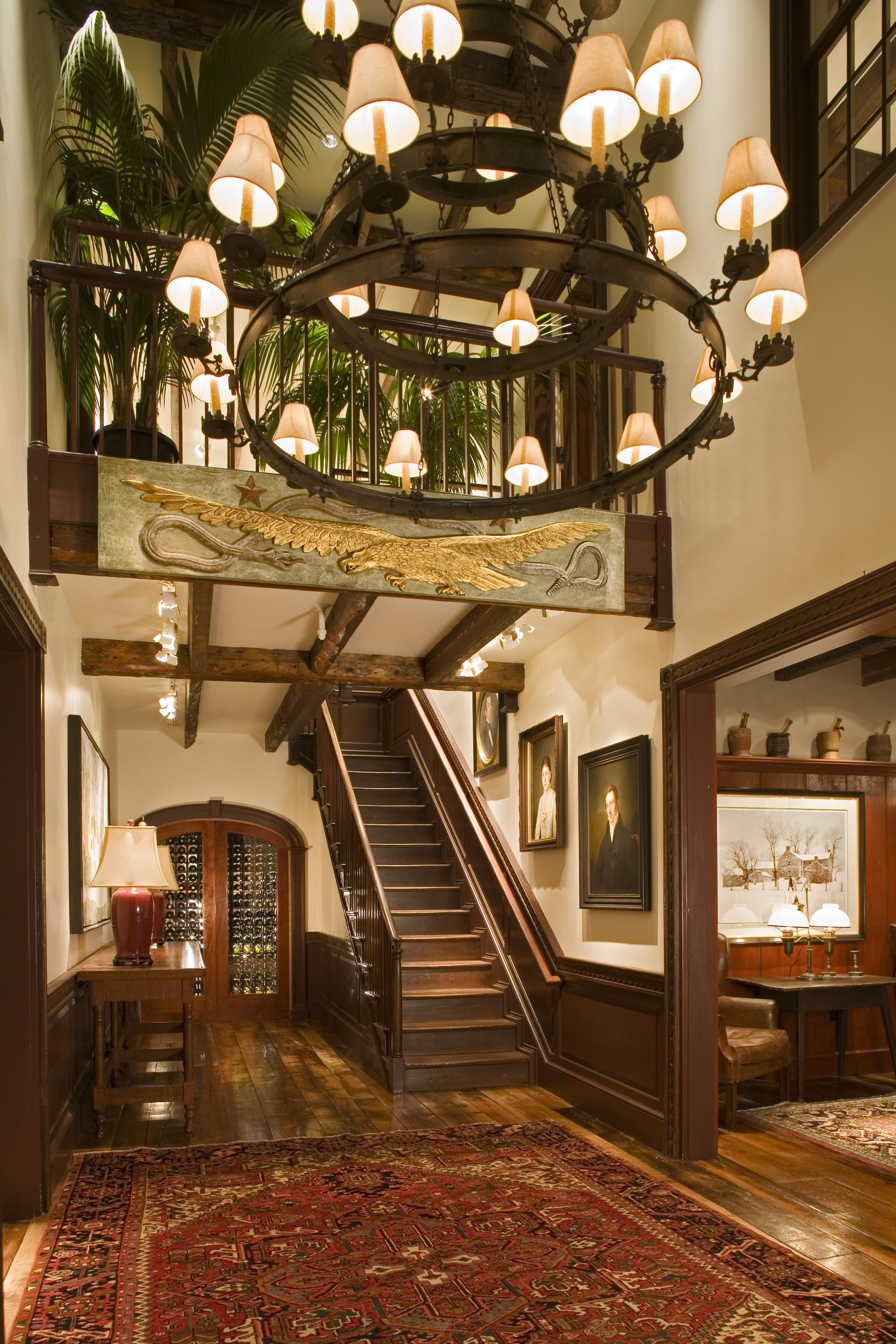 A hallway with stairs and a chandelier hanging from the ceiling
