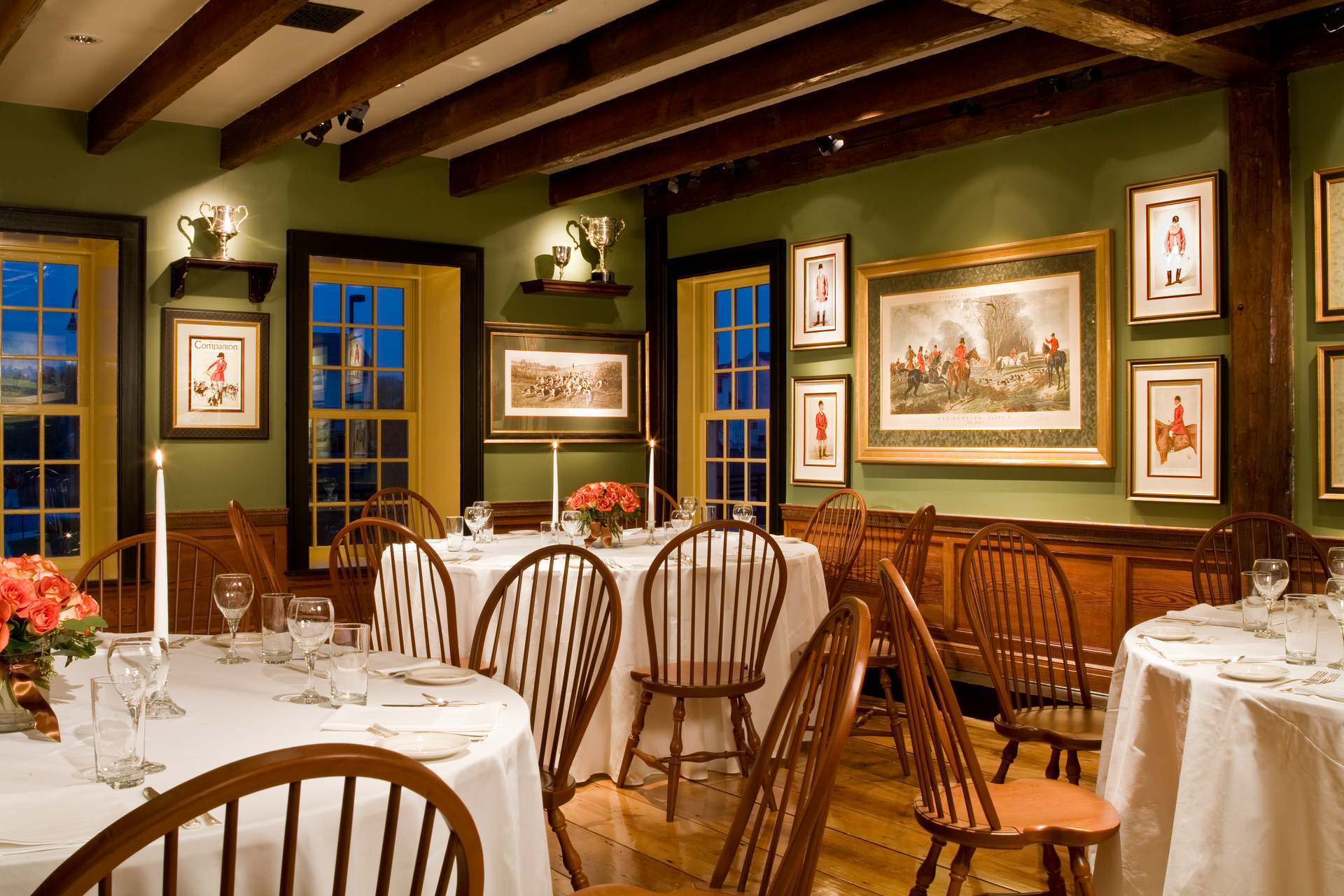 A dining room with tables and chairs and paintings on the wall