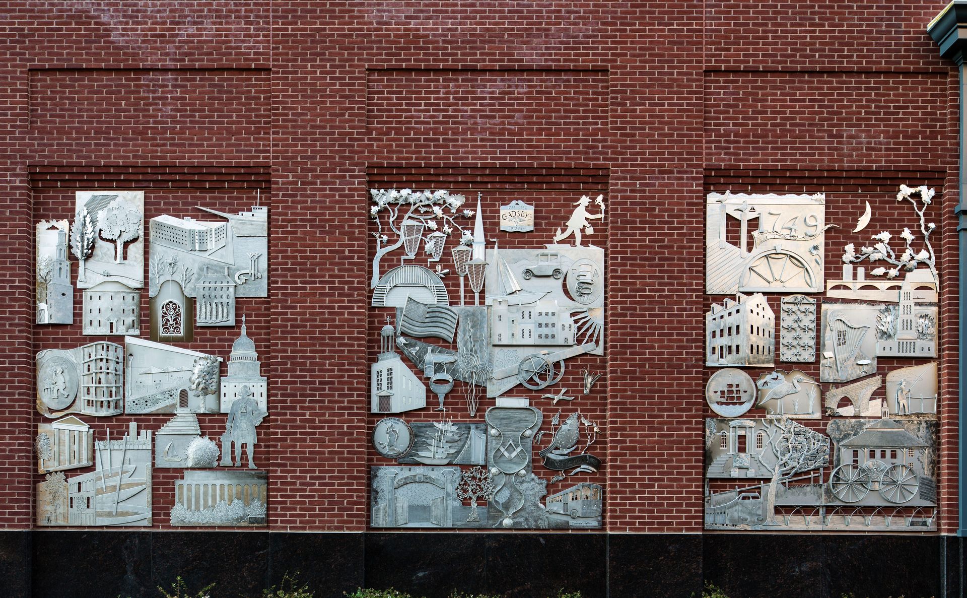 A brick wall with a lot of pictures on it