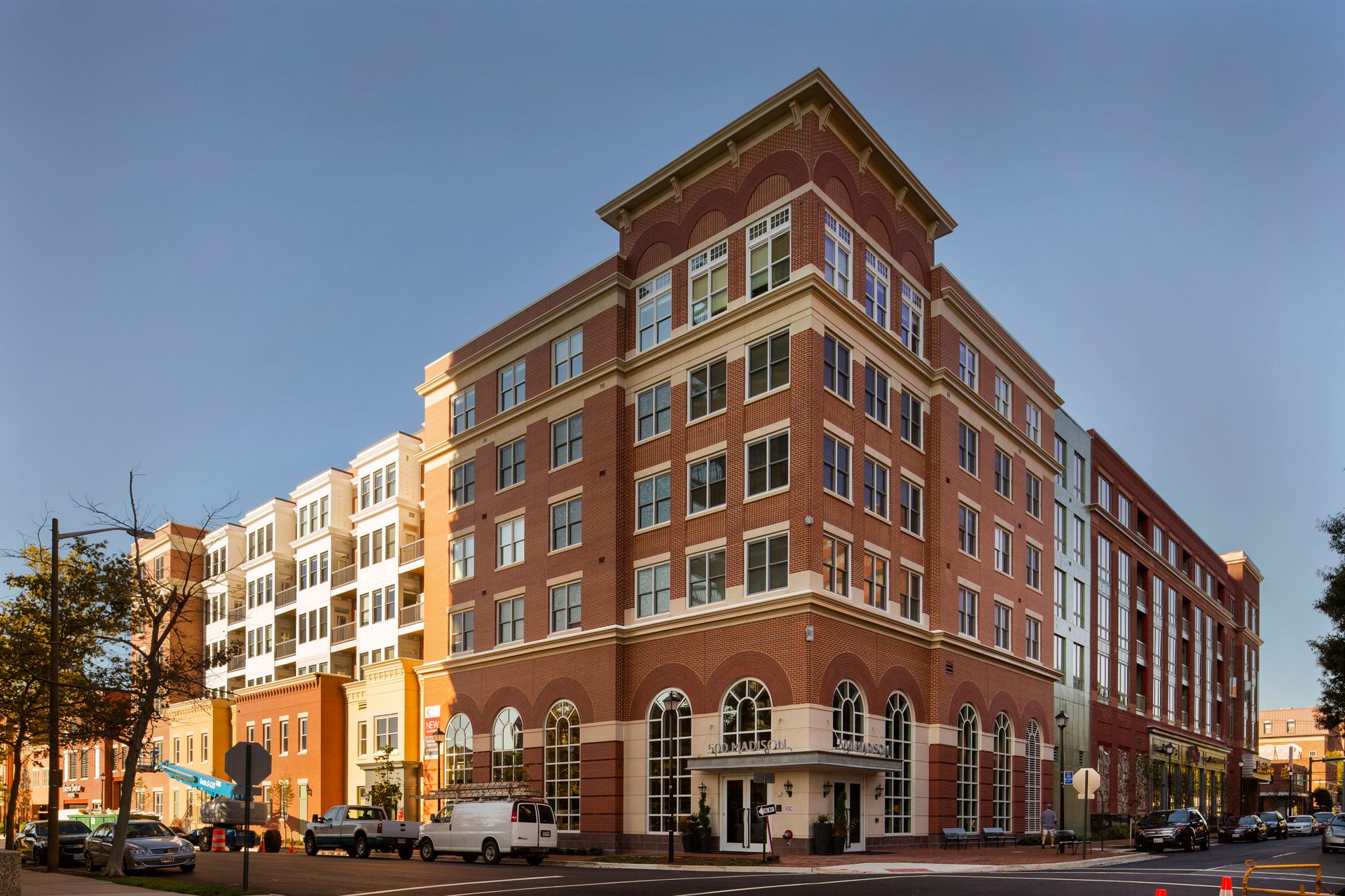 A large brick building is sitting on the corner of a city street.