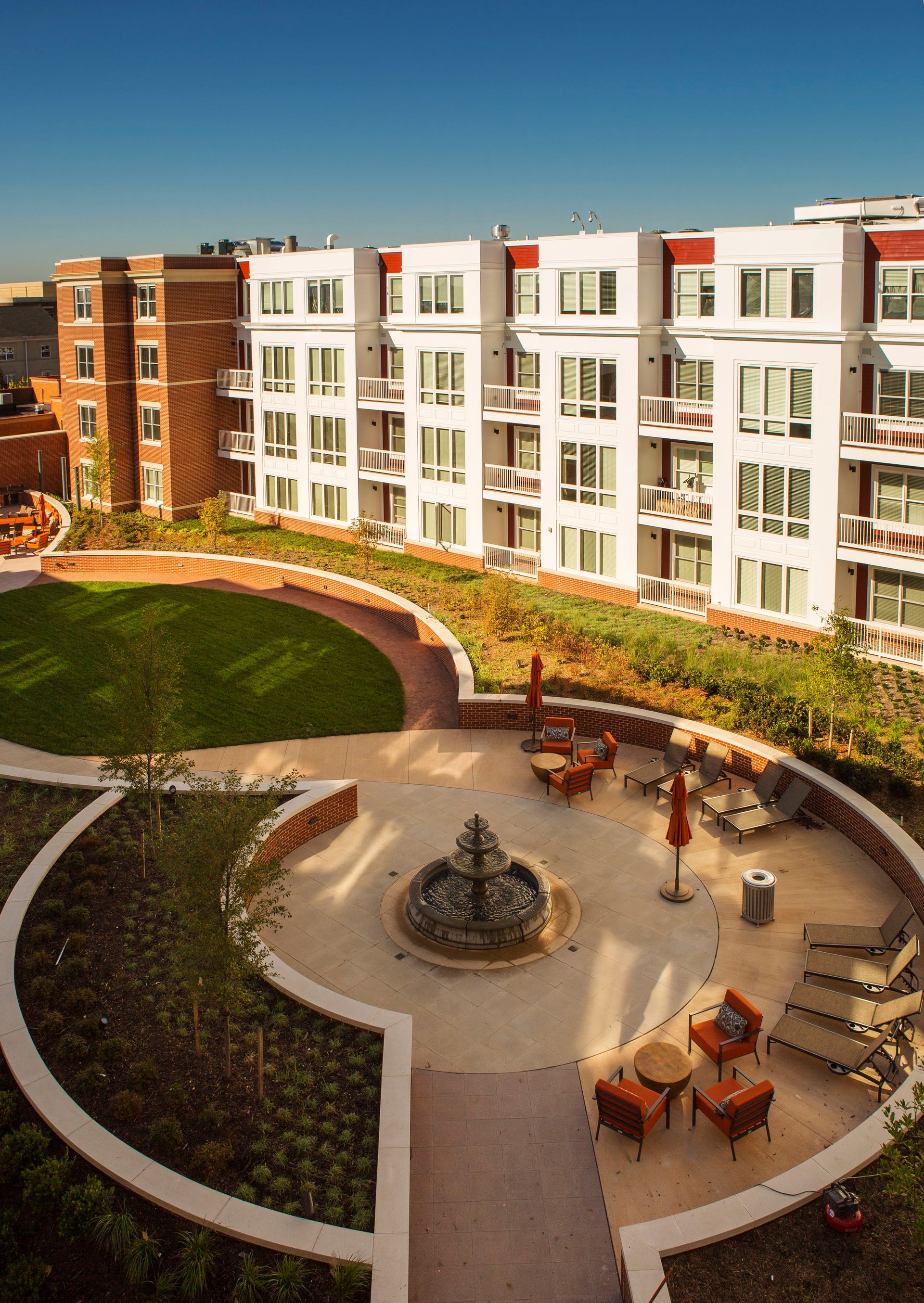An aerial view of a large apartment building with a fountain in the middle