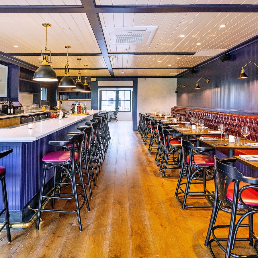 A restaurant with a long row of tables and chairs