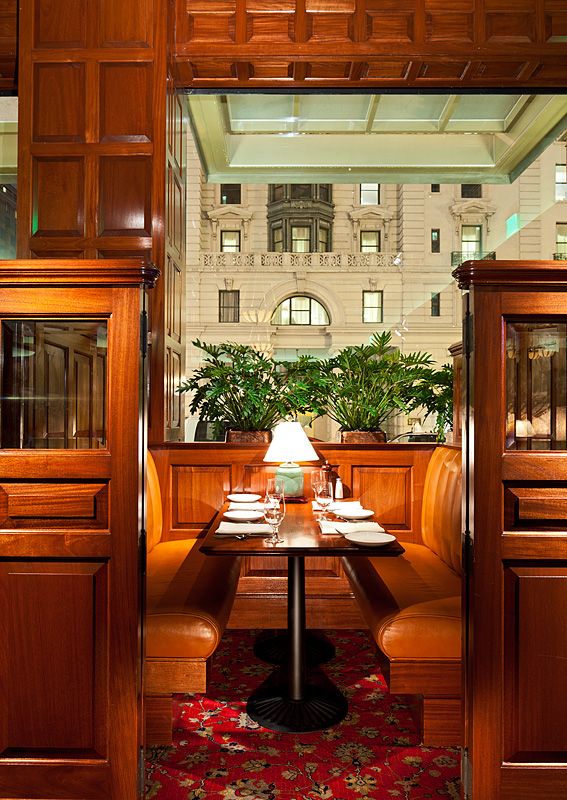 A restaurant booth with a table and chairs in front of a building.