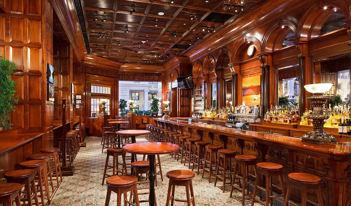 A restaurant with a long bar and tables and stools