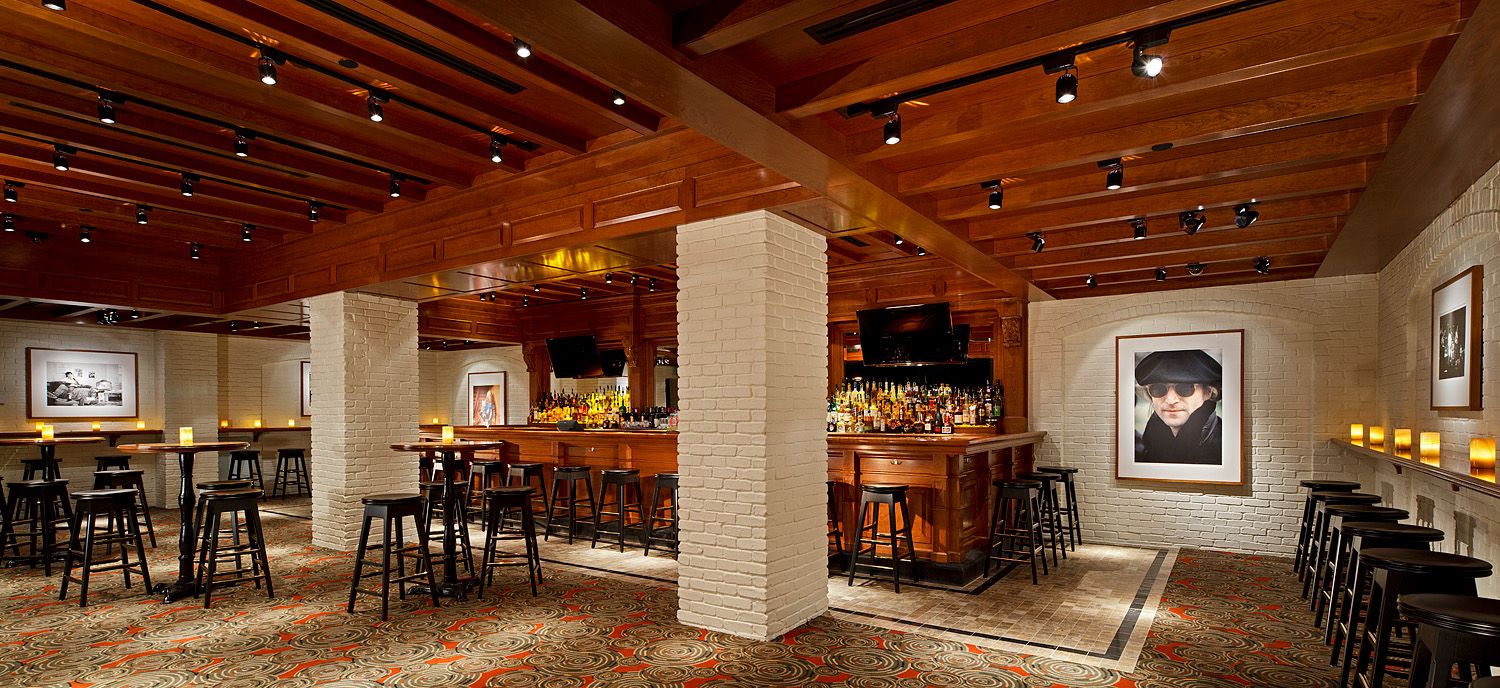 A large room with tables and chairs and a bar.