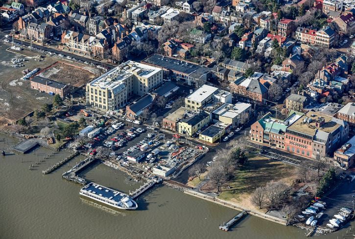 An aerial view of a city with a boat docked in the water.