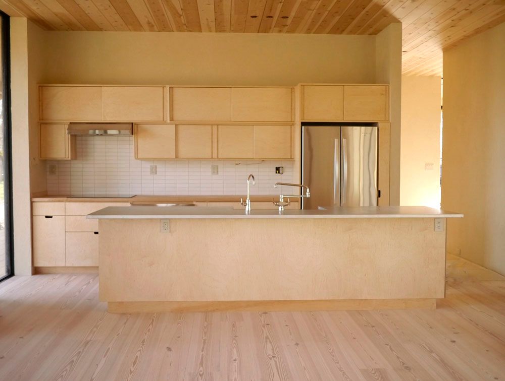 A kitchen with wooden cabinets and a stainless steel refrigerator