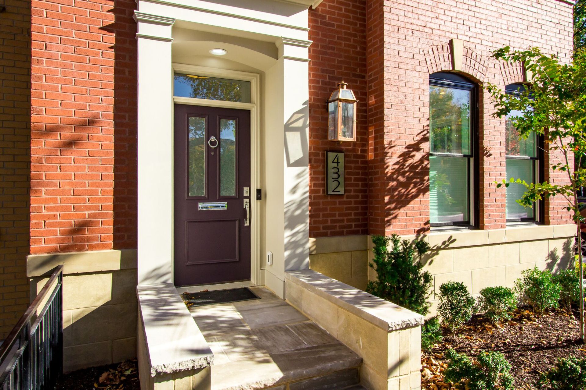 The front door of a brick house with a purple door