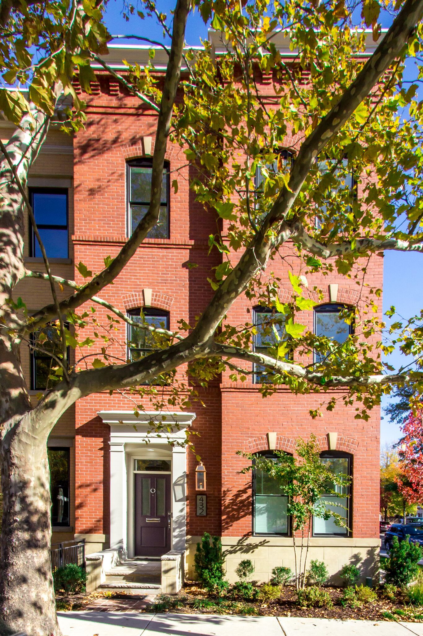 A large red brick building with a tree in front of it.