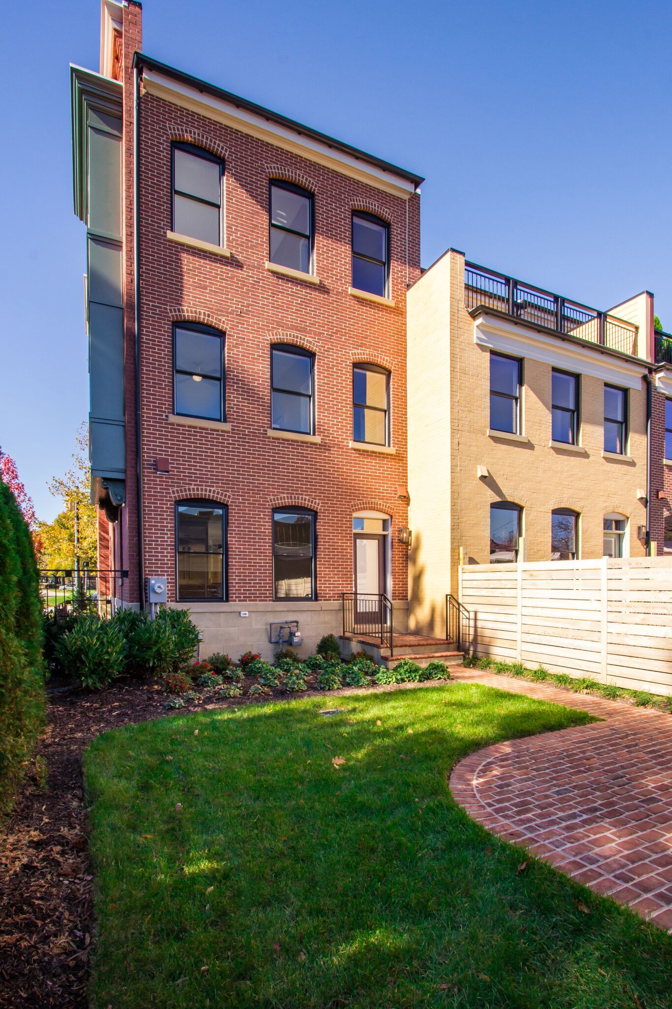 A large brick building with a lush green lawn in front of it.