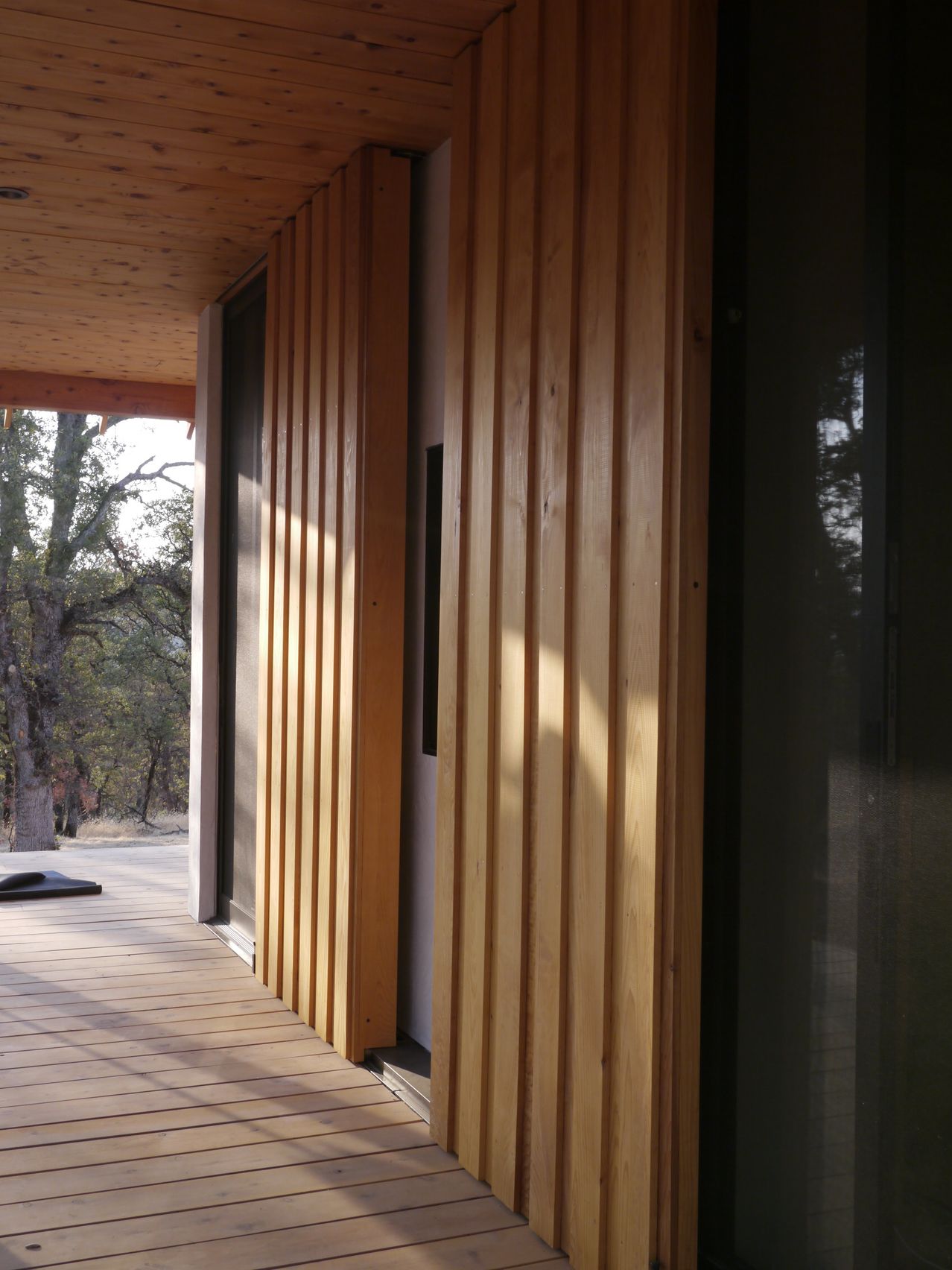 A wooden wall with a reflection of trees in it
