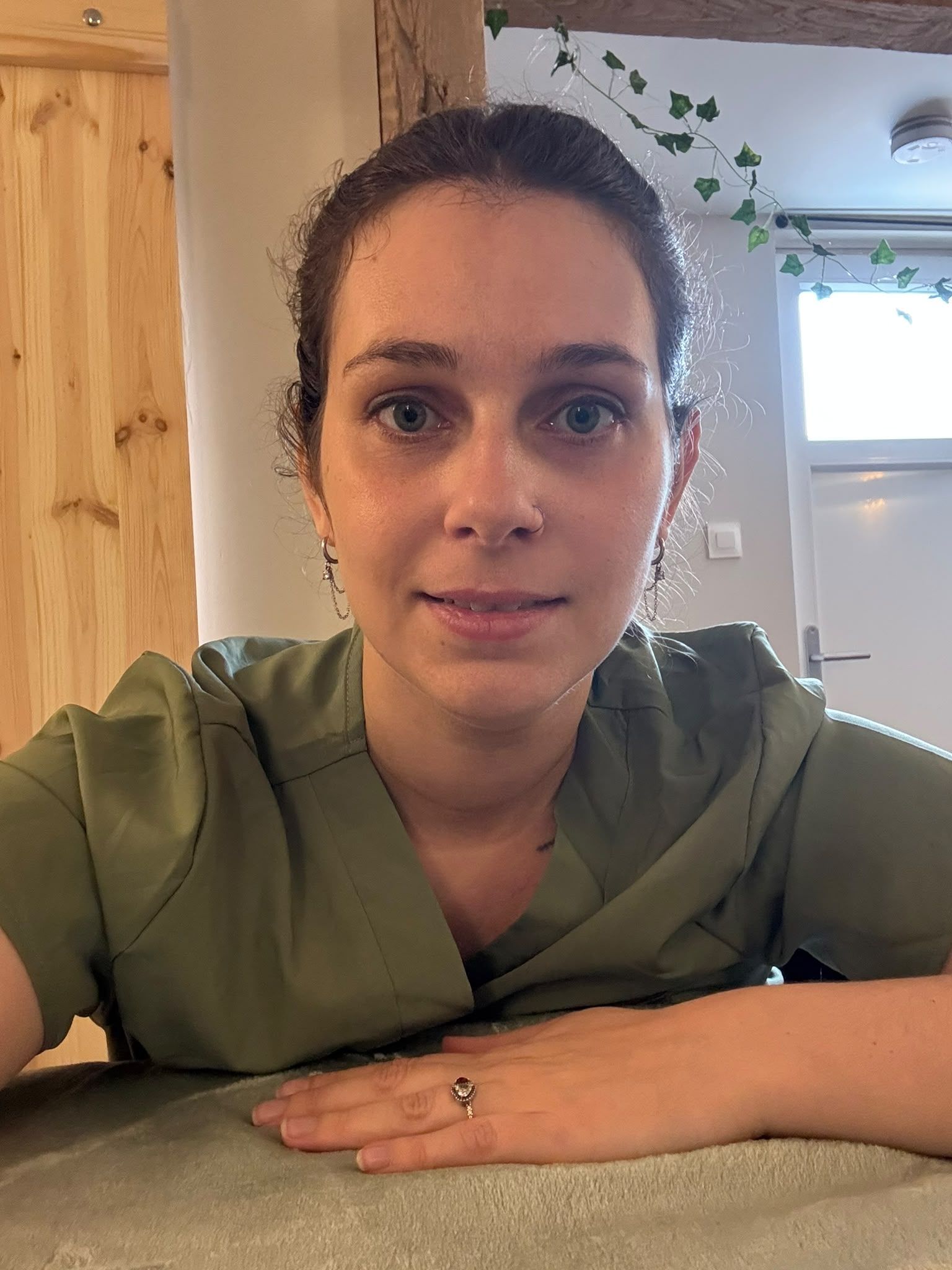 Un kinésithérapeute souriant soigne un patient allongé sur une table de soins