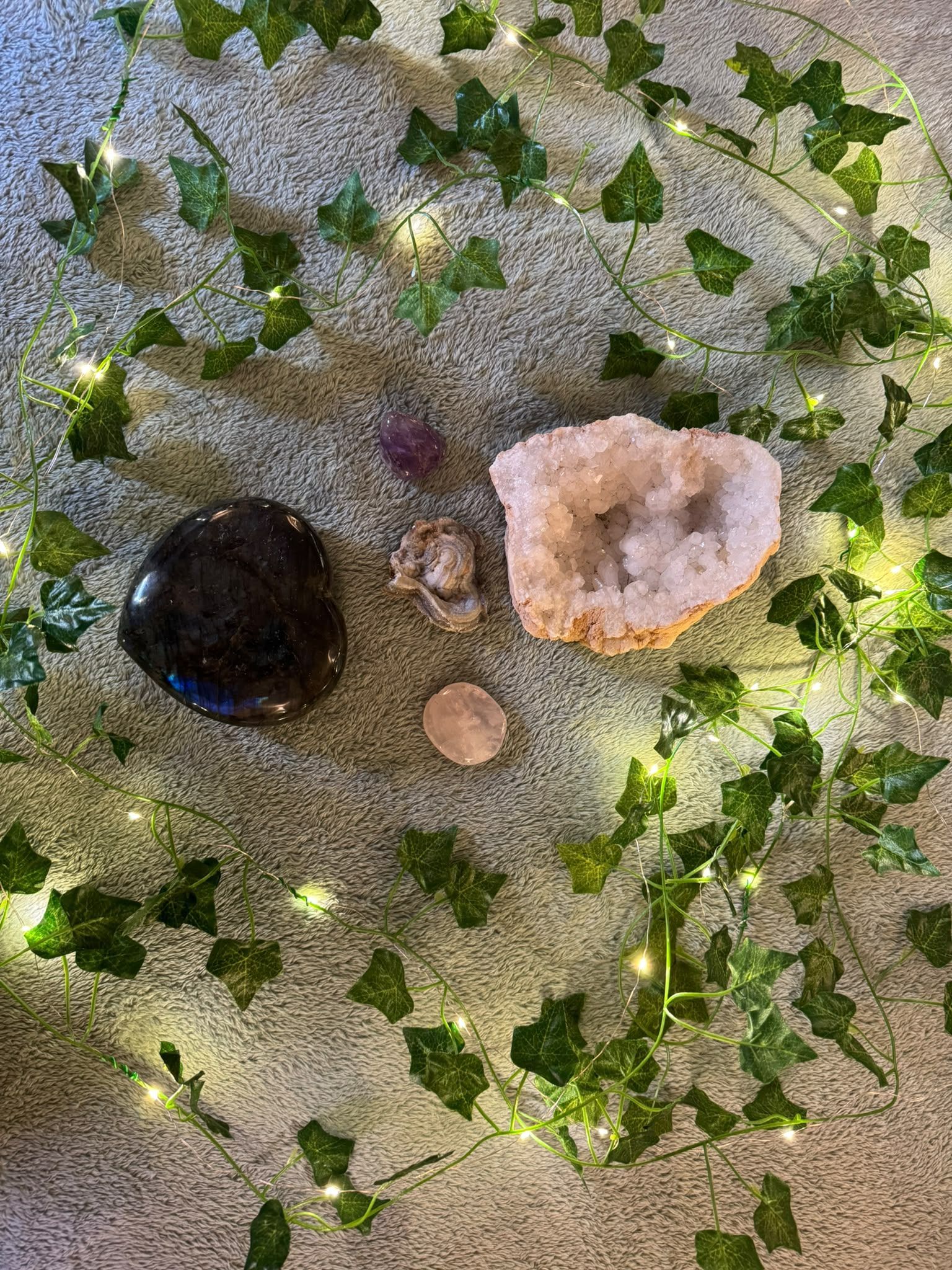 Trois cristaux sur des paillettes argentées scintillantes, ornés de feuilles de lierre vertes