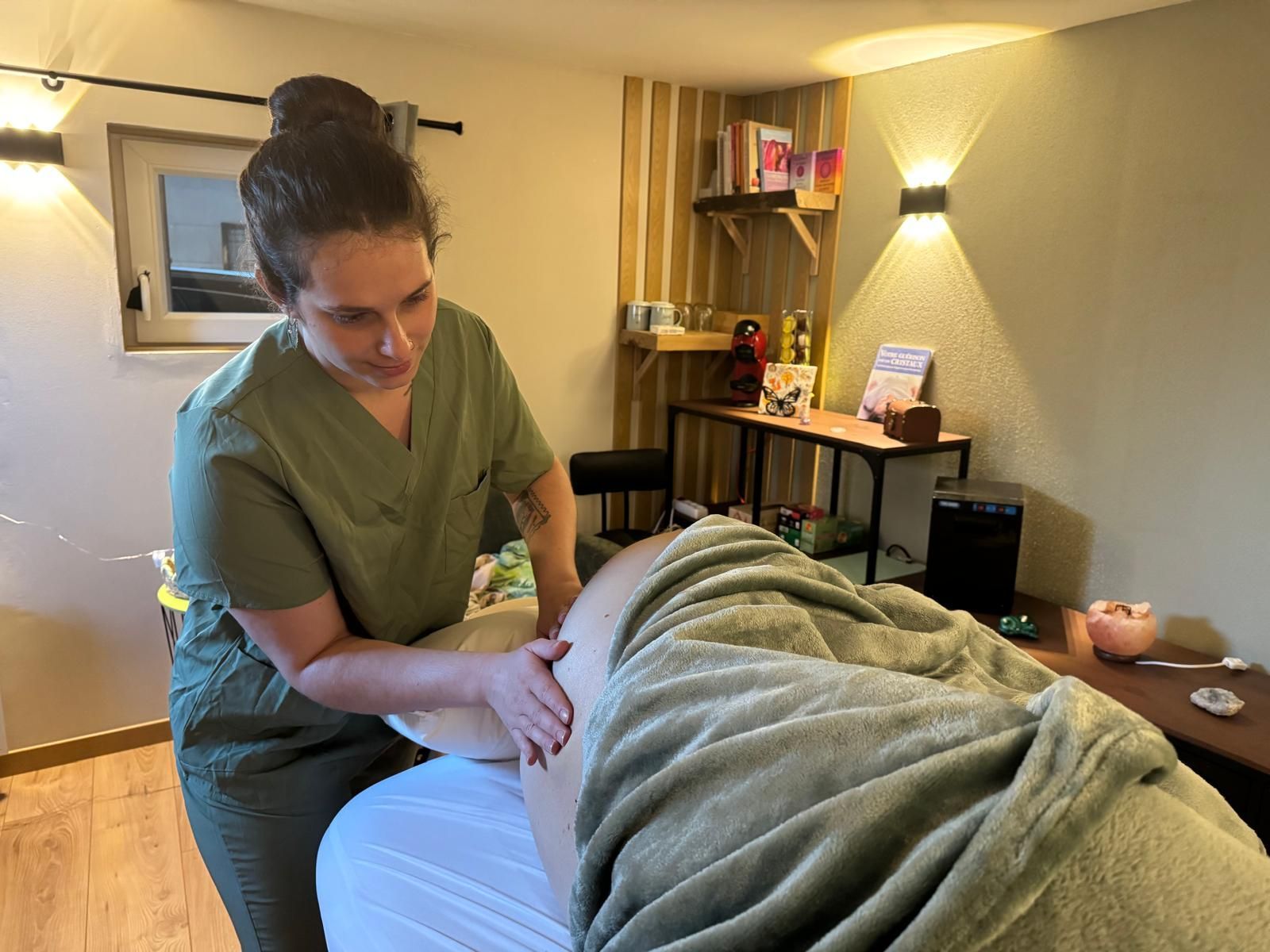 Une personne qui donne un massage dans une pièce à la lumière tamisée, avec un client.