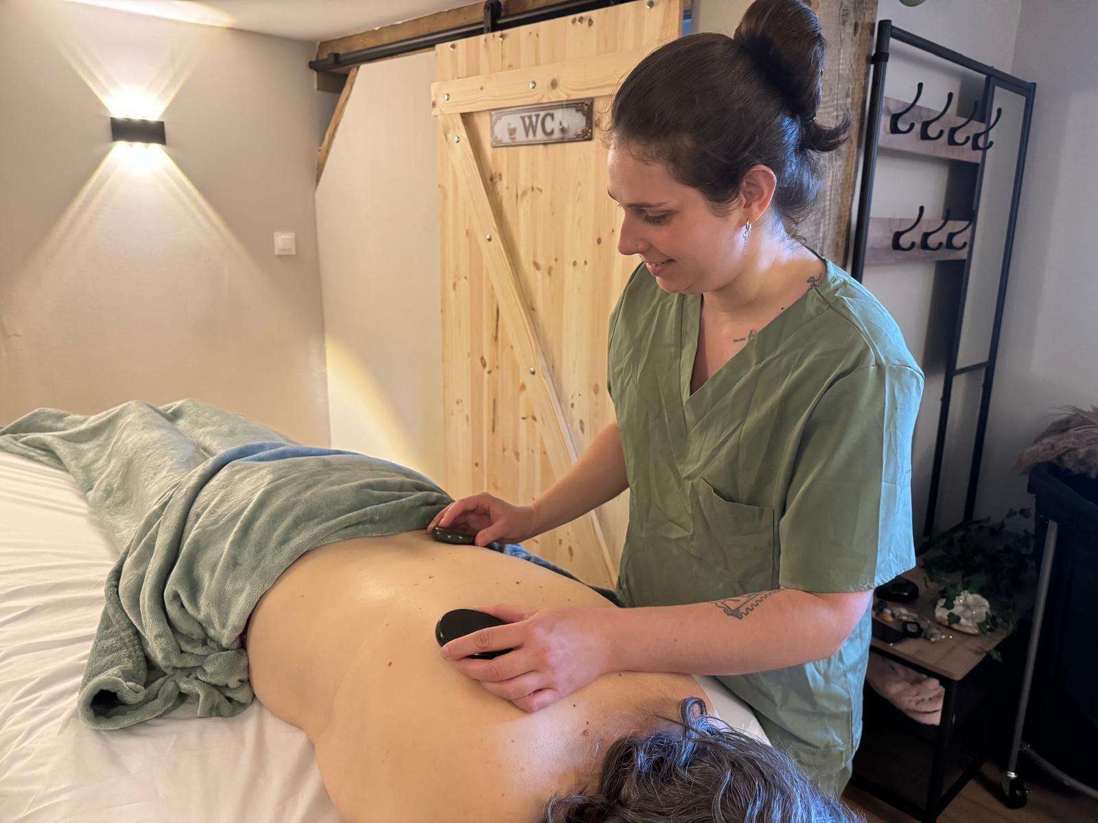 Un masseur travaille sur le dos d’un client dans une salle de soins calme