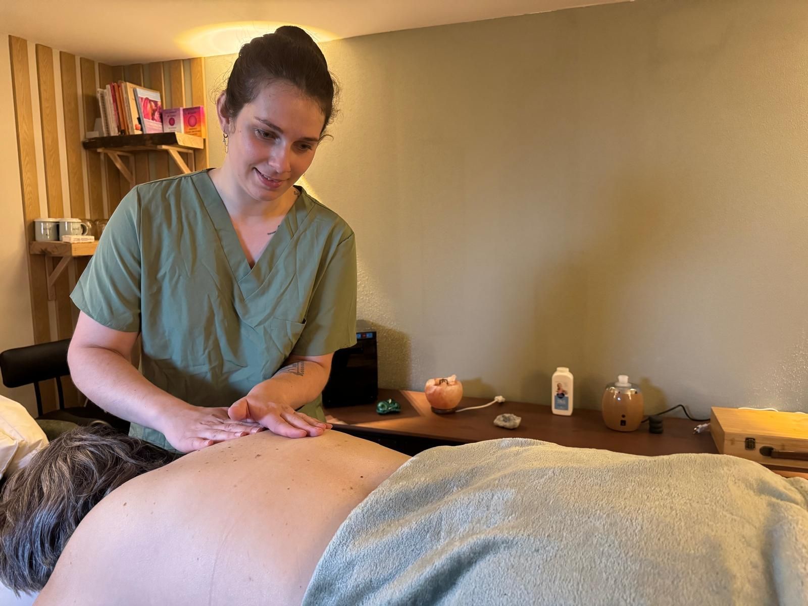 Un praticien en massage qui masse le dos d’un client