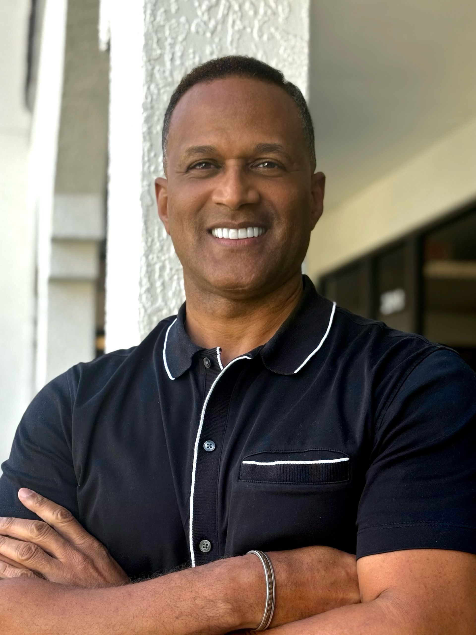 Smiling man holding up a car key on a white background Smiling man holding up a car key on a white background