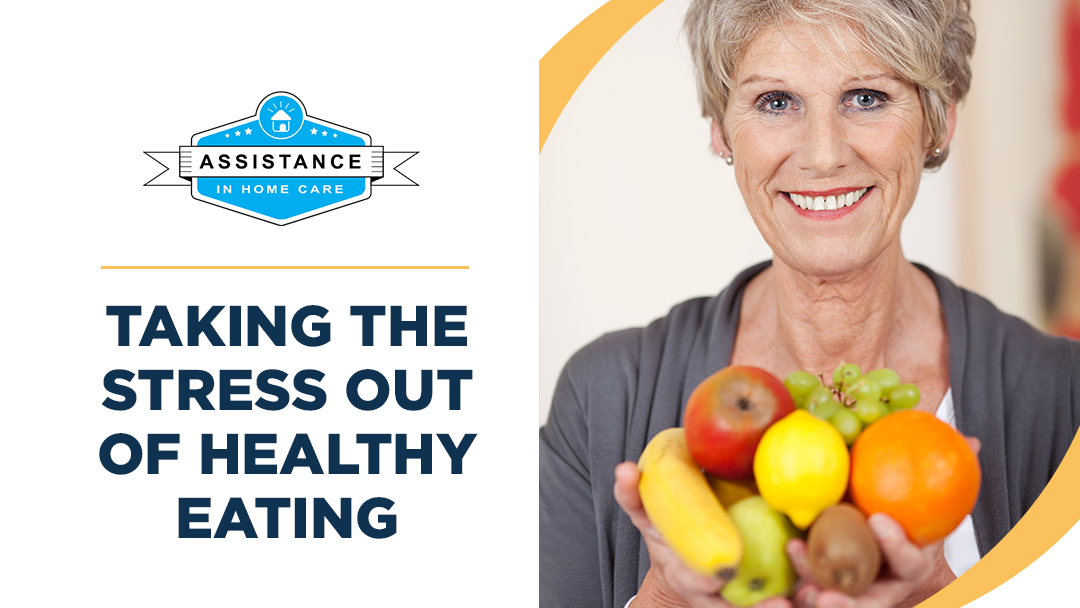 An older woman is holding a bowl of fruit and smiling.