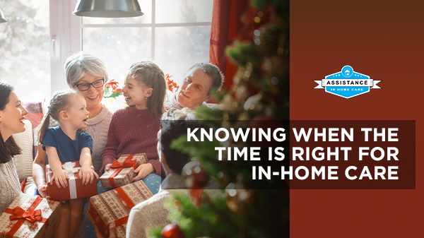 A family is sitting at a table with christmas presents in front of a christmas tree.