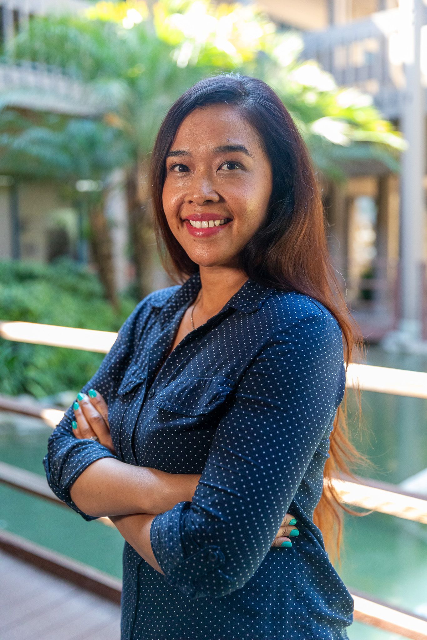 A woman in a blue shirt is smiling for the camera.