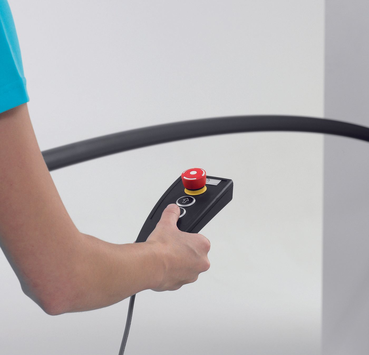 A person is holding a remote control with a red button on it