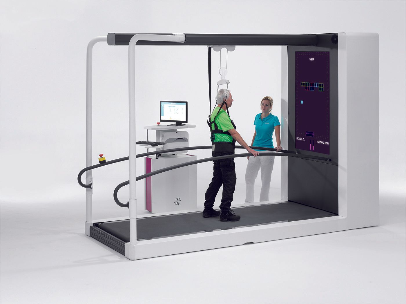 A man is walking on a treadmill while a woman looks on.