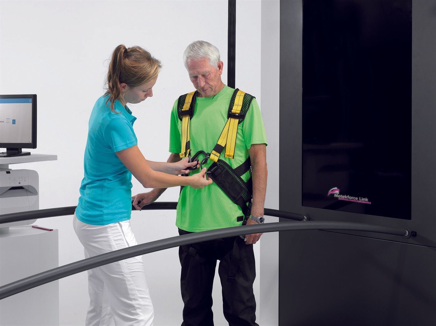 A woman is helping an older man with a harness