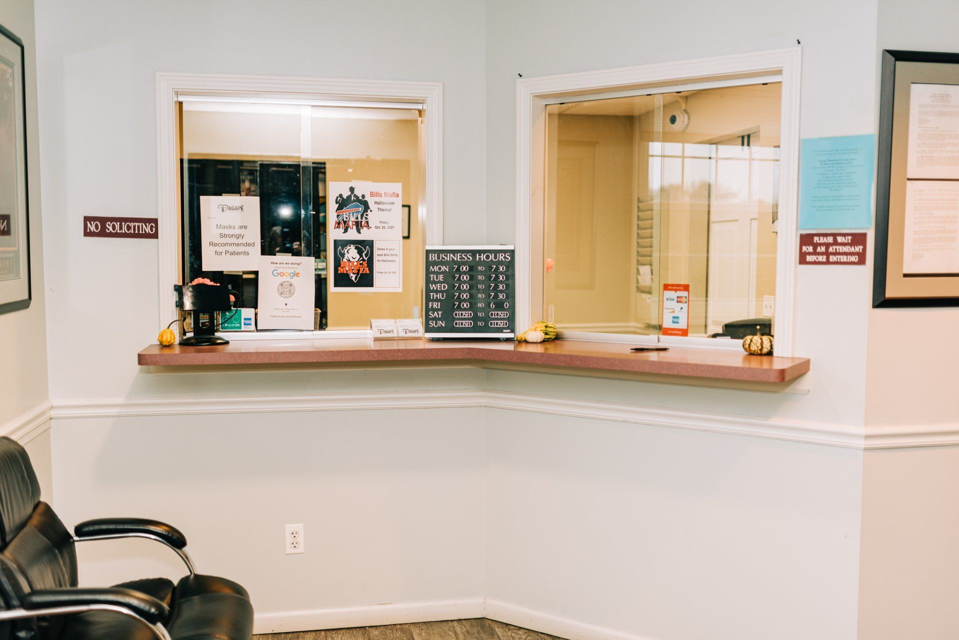 A waiting room with a chair and a counter in a hospital.