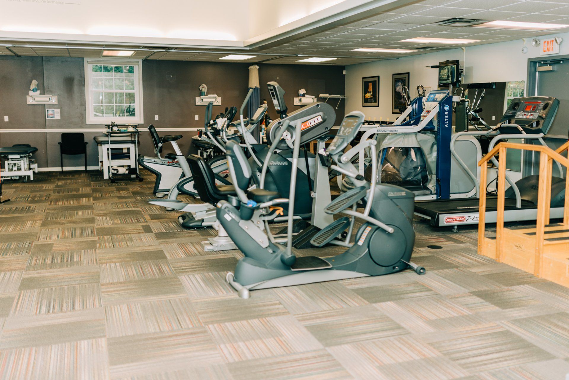 A gym filled with a variety of exercise bikes and treadmills.