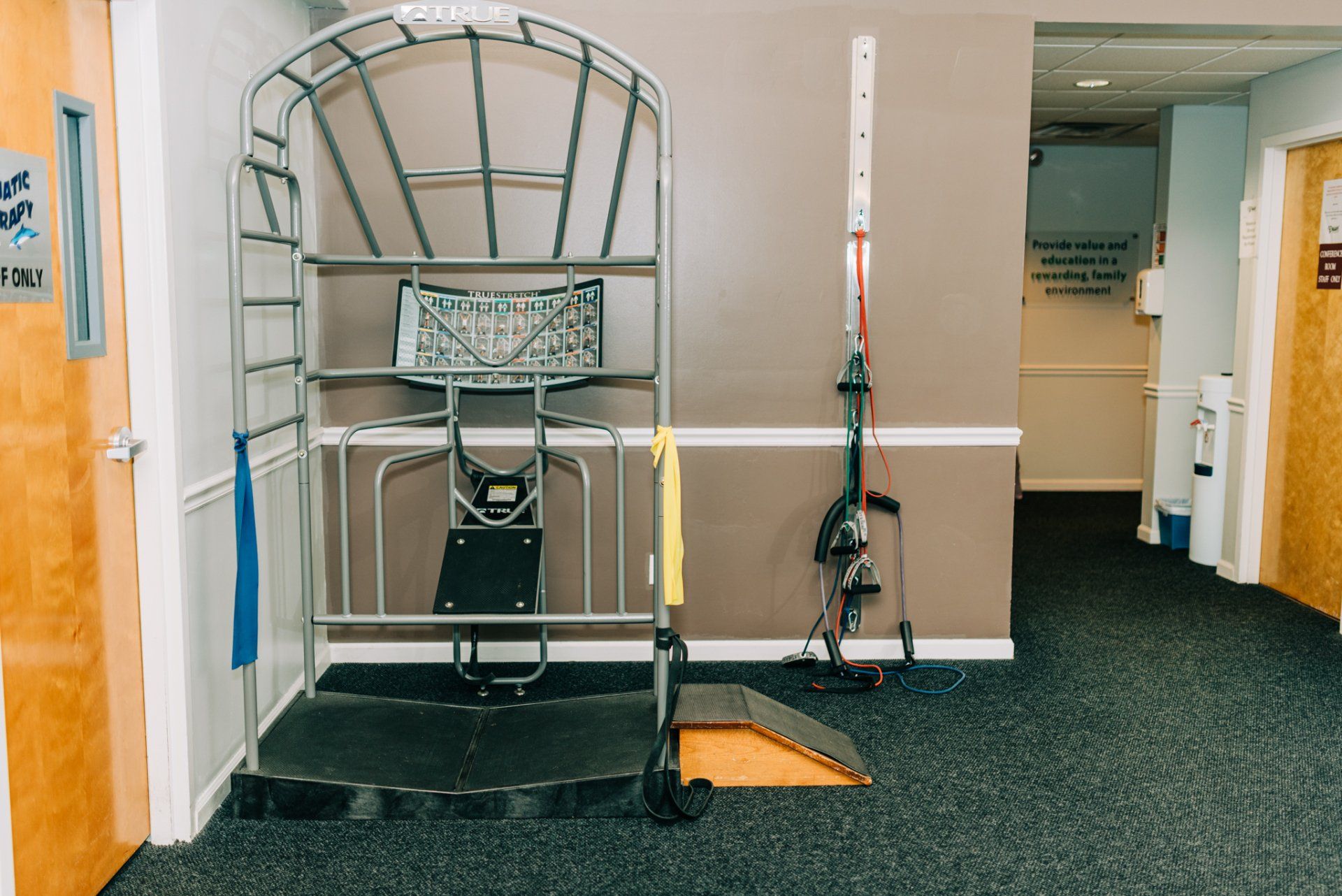 A basketball hoop is sitting in a hallway next to a door.