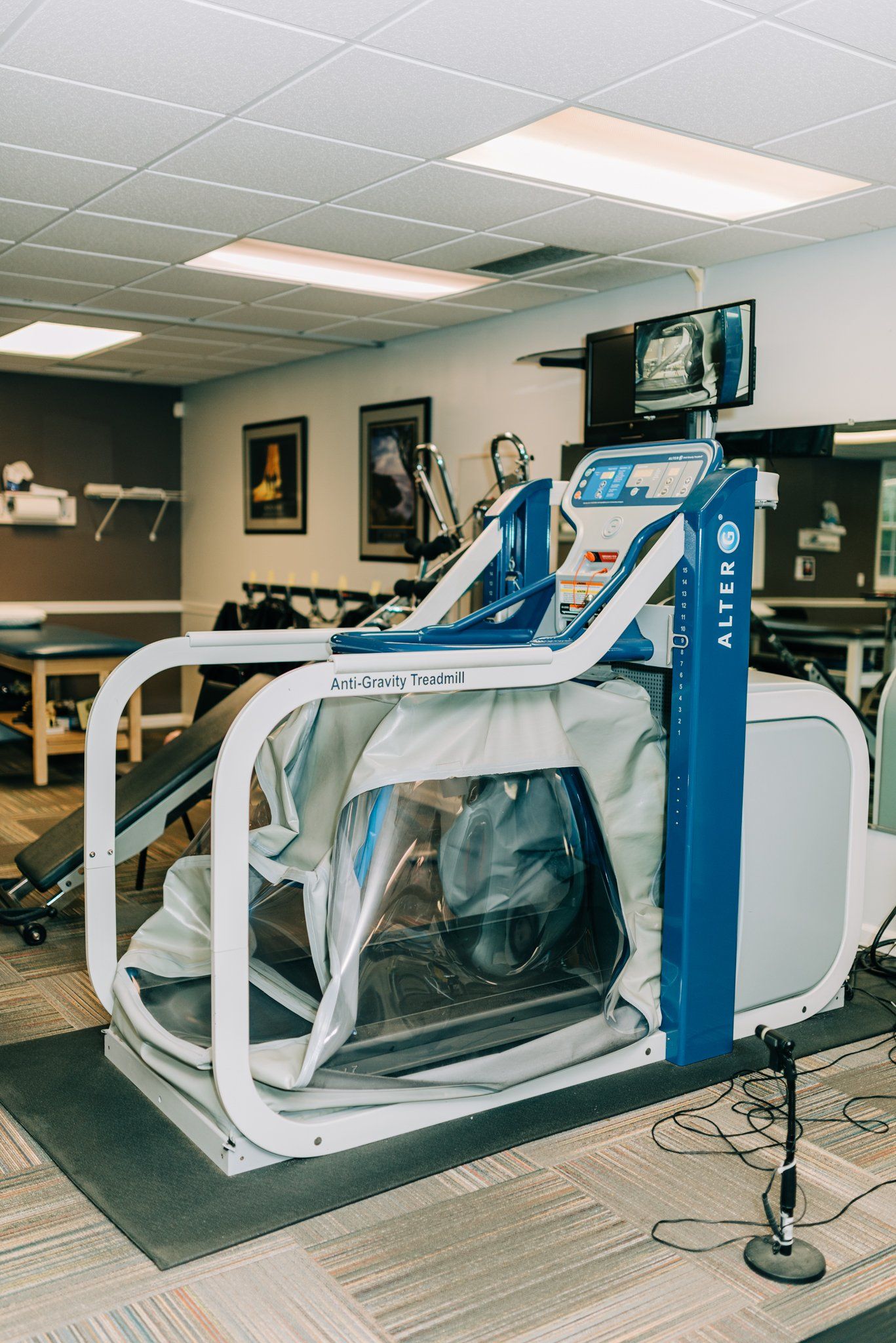 A treadmill is sitting in a gym next to a microphone.