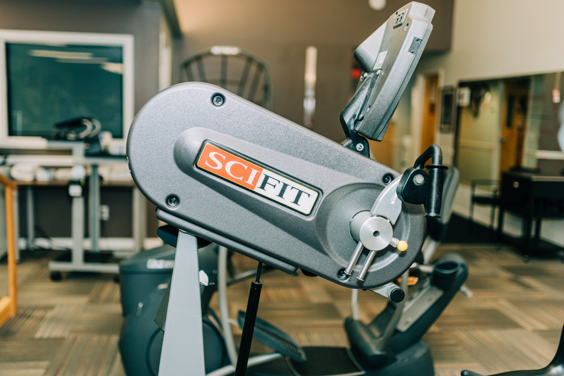 A scifit exercise bike is sitting in a gym.