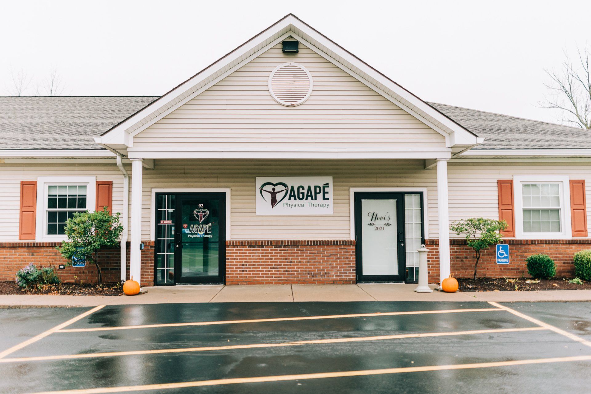 The front of a building with a parking lot in front of it.