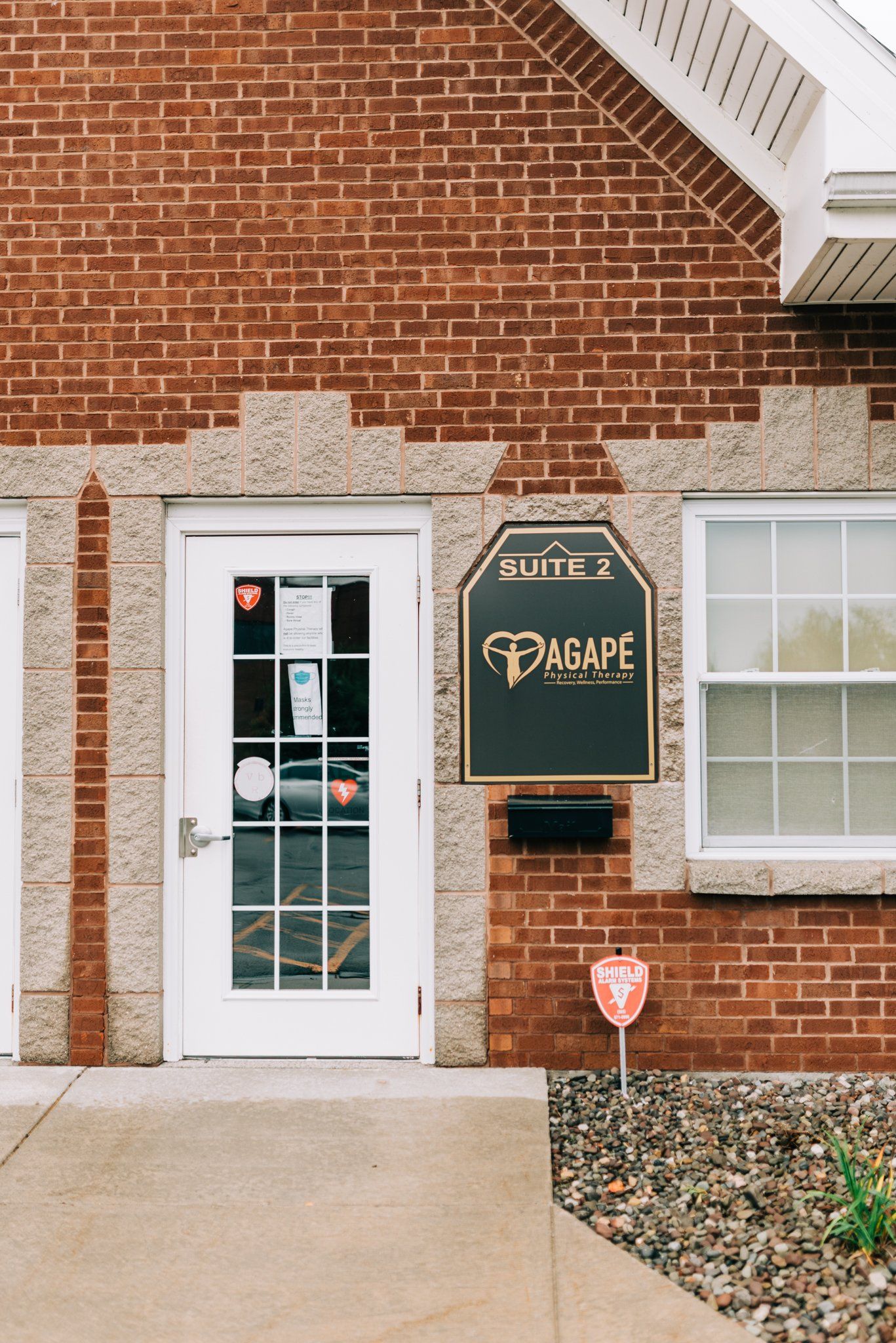A brick building with a white door and a sign that says dasape
