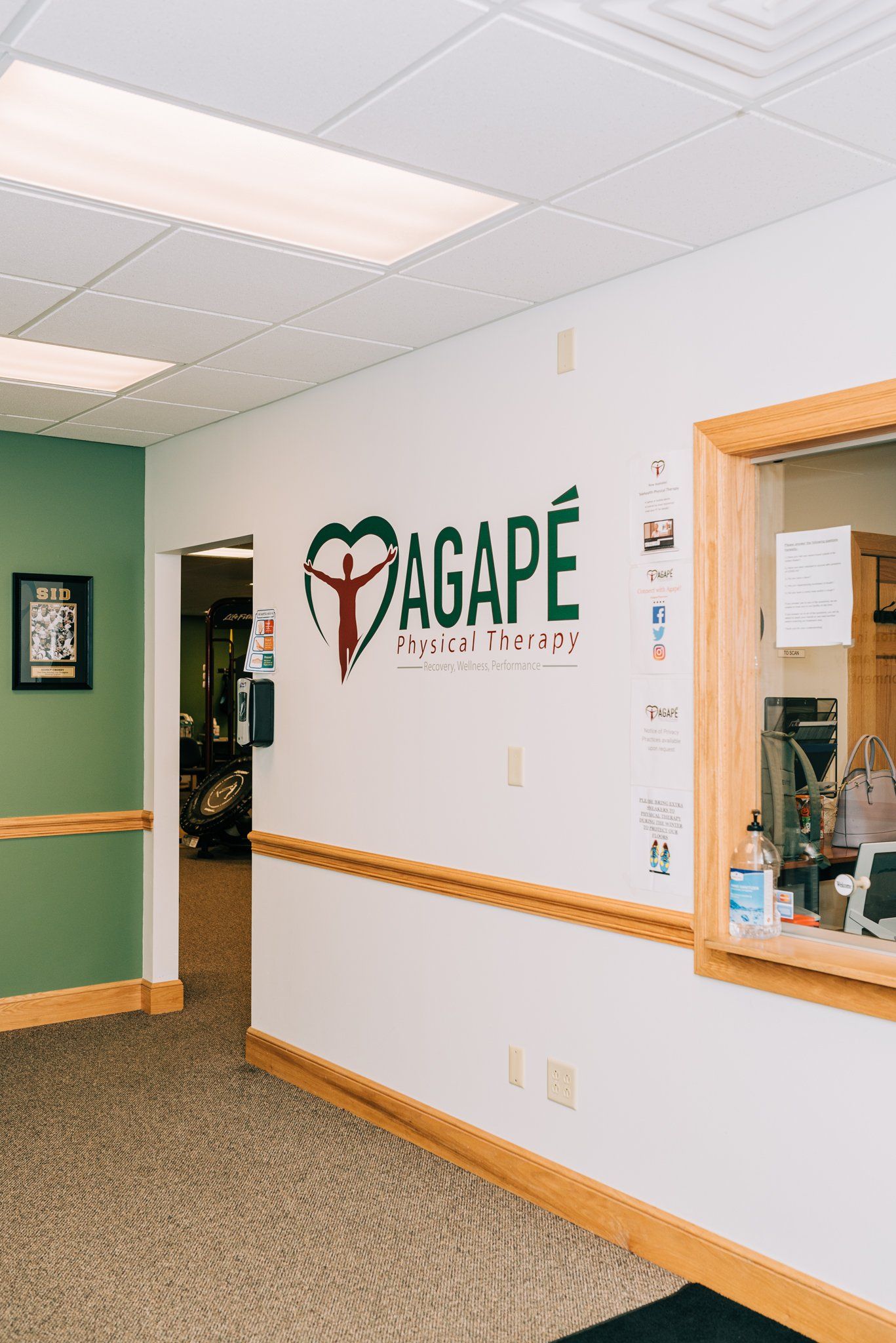 A hallway with a sign on the wall that says agape physical therapy.
