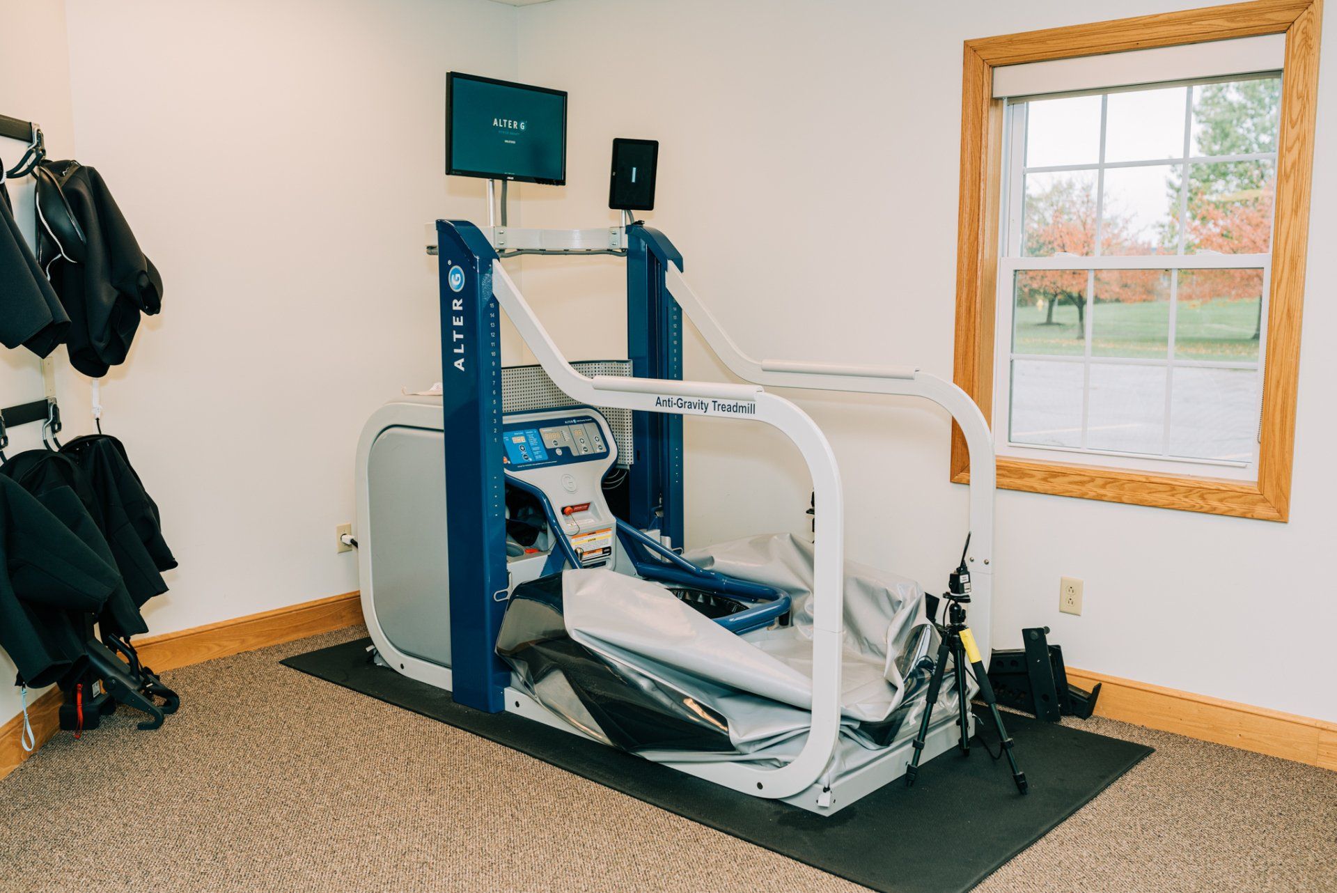 A treadmill is sitting in a room next to a window.