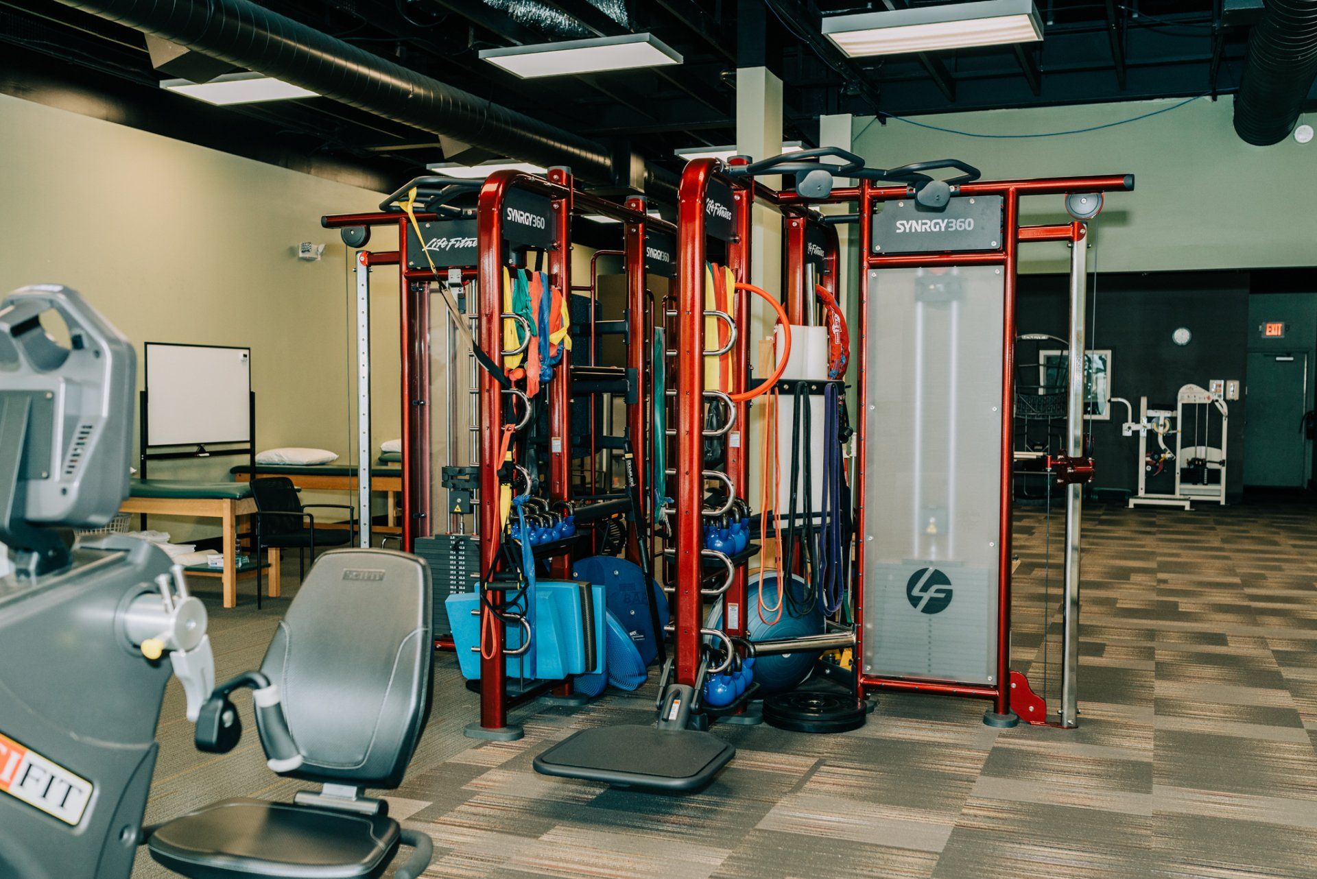 A gym with a lot of exercise equipment in it.