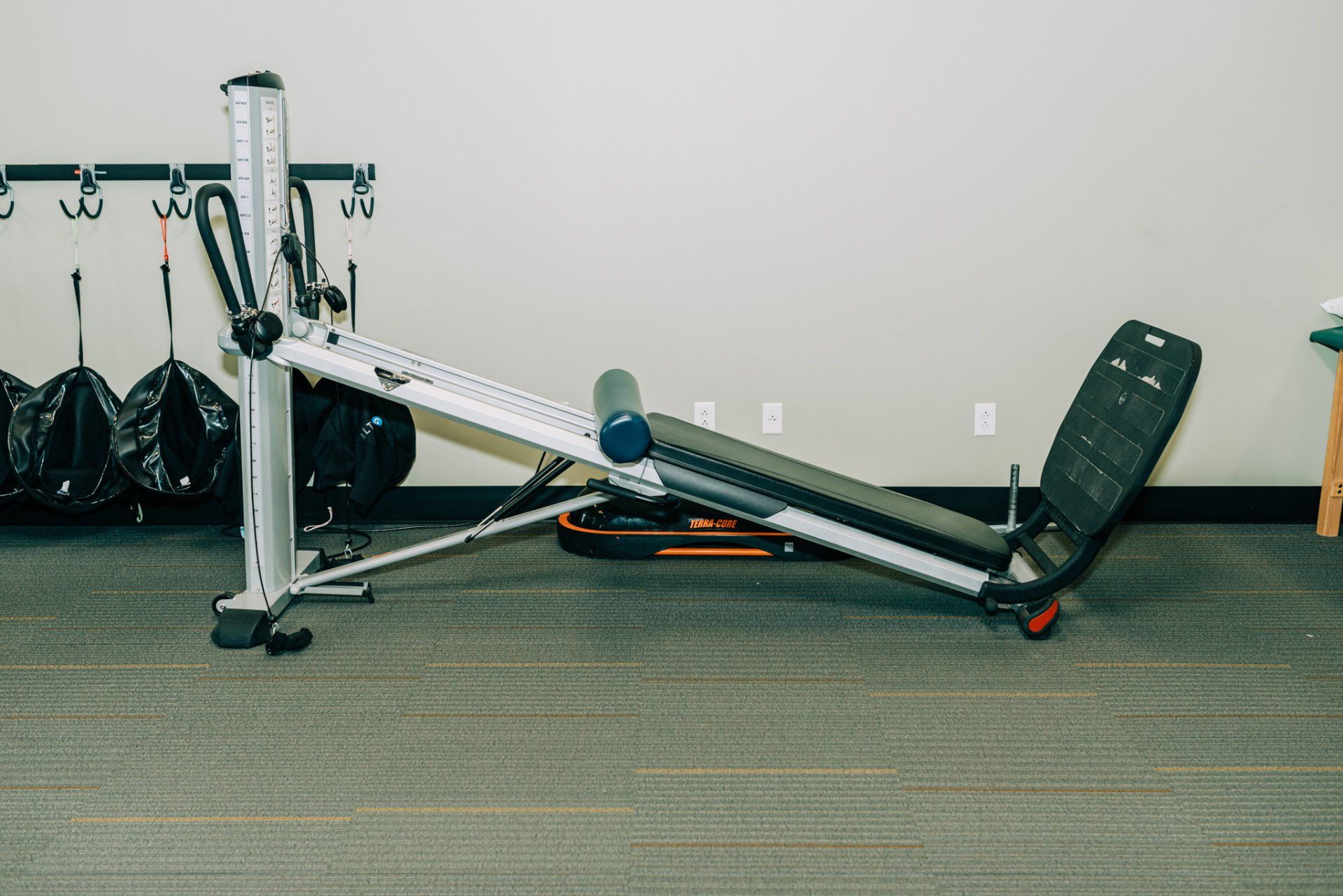 A gym machine is sitting on the floor in a room.