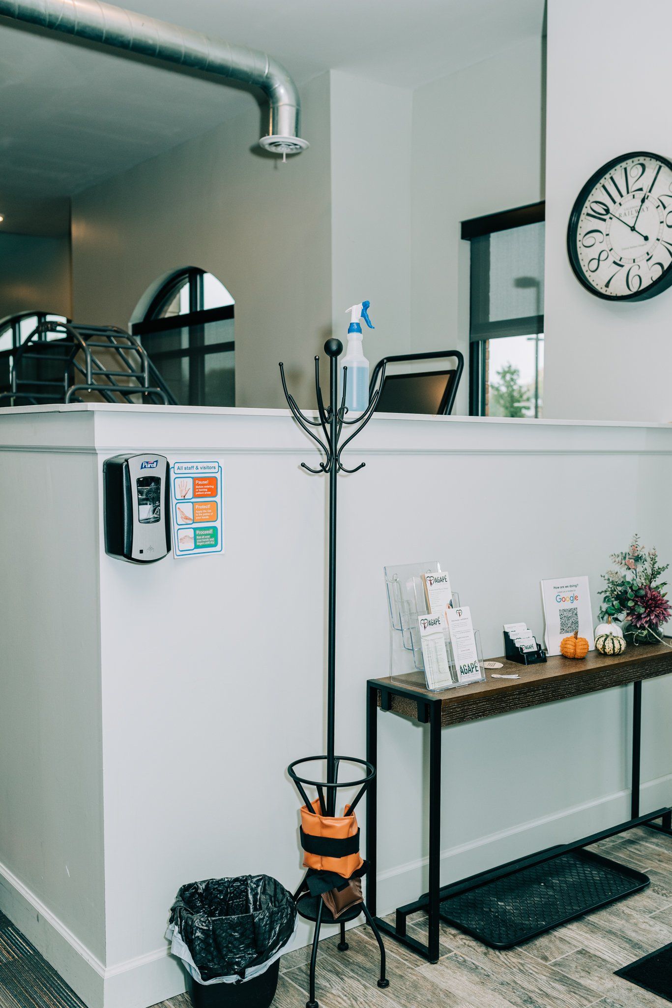 There is a clock on the wall above the table.